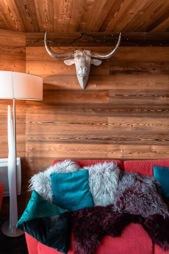 une chambre avec un canapé avec une tête de cerf sur le mur dans l'établissement IMMODREAMS - Le Lodge, à Avoriaz