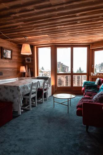 un salon avec une table, des chaises et des fenêtres dans l'établissement IMMODREAMS - Le Lodge, à Avoriaz