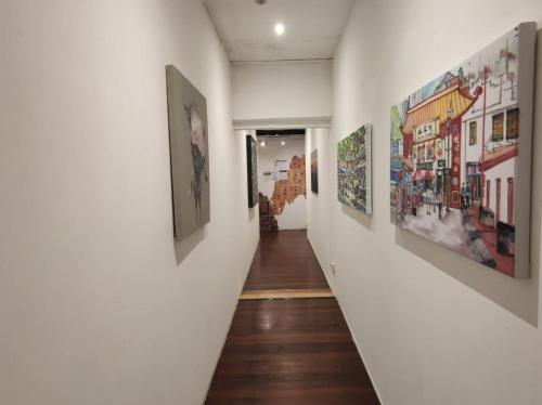 a hallway with paintings on the walls at BEAT Arts Hostel at Chinatown in Singapore