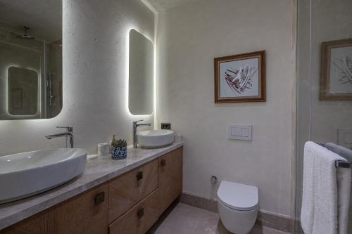 a white bathroom with a sink and a toilet at Swissôtel Living Bodrum in Bodrum City