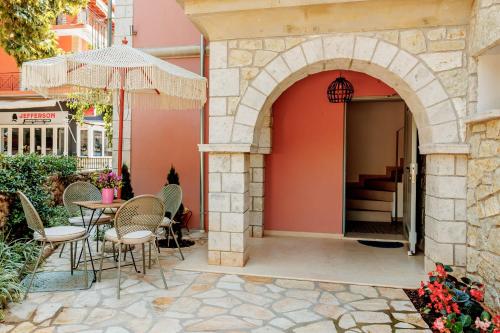 un patio con mesa, sillas y un arco en PargaMondo Countryliving en Parga