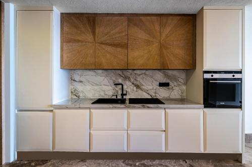 a kitchen with white cabinets and a sink at Swissôtel Living Bodrum in Bodrum City