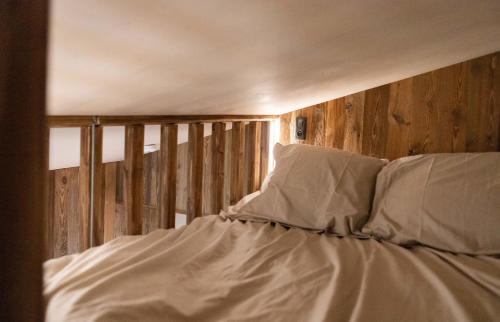 łóżko z białą pościelą i poduszkami w pokoju w obiekcie IMMODREAMS - La Cabane w mieście Morzine