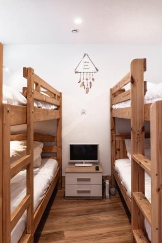 - une chambre avec 2 lits superposés et une télévision dans l'établissement IMMODREAMS - Le Proclou, à Morzine