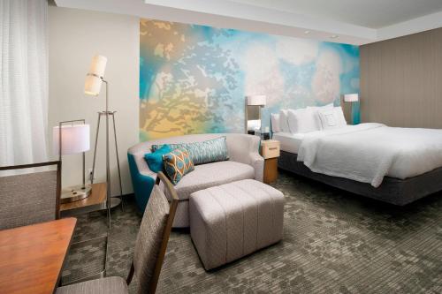 Pokój hotelowy z łóżkiem i krzesłem w obiekcie Courtyard by Marriott Nashville SE/Murfreesboro w mieście Murfreesboro