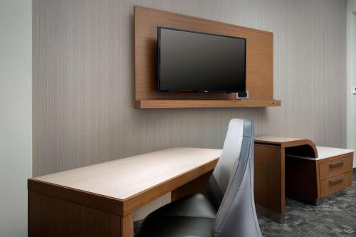 a room with a desk and a tv on a wall at Courtyard by Marriott Nashville SE/Murfreesboro in Murfreesboro