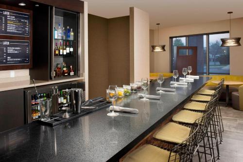 a bar with chairs and a counter with wine glasses at Courtyard by Marriott Nashville SE/Murfreesboro in Murfreesboro