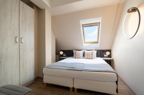 a bedroom with a bed and two tables and a window at Hotel & Spa Trzy Wyspy in Świnoujście