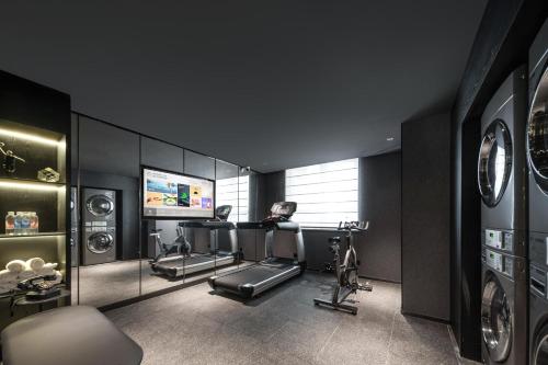 a gym with treadmills elliptical machines and a television at Atour Hotel Yuyao Nanlei Building in Ningbo