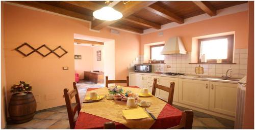 una cocina con mesa y sillas y una cocina con mesa y mesa. en Borgo delle Panie en Careggine