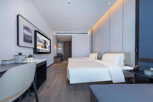una camera d'albergo con un grande letto bianco e una scrivania di Atour Hotel Xiapu Fujian a Fuzhou