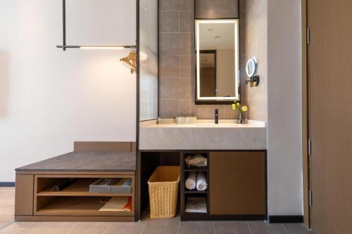 een badkamer met een wastafel en een spiegel bij Atour Hotel Xiapu Fujian in Fuzhou
