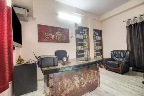 Super OYO Hotel Elite Inn في Korādih: غرفة مع بار مع كرسي ومكتب
