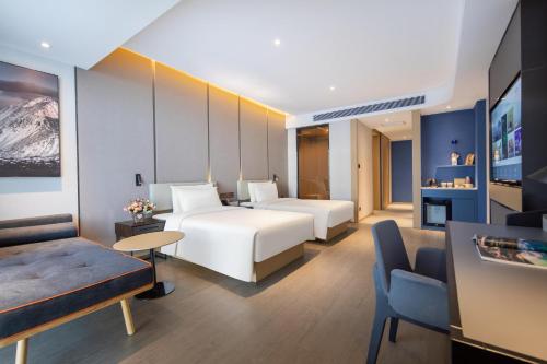 pokój hotelowy z 2 łóżkami i kanapą w obiekcie Atour Hotel Jincheng Gaoping High-Speed East Railway Station w mieście Gaoping