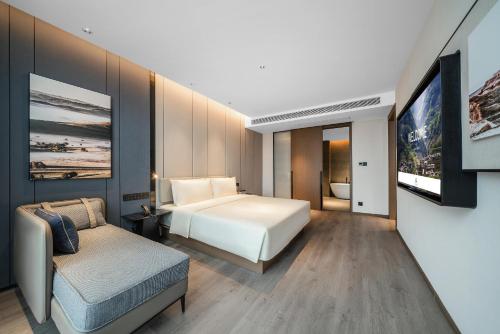 a hotel room with a bed and a couch at Atour Hotel Chongqing Liangjiang District Jinke Center in Chongqing