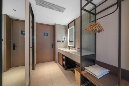 a bathroom with a sink and a mirror at Atour Hotel Chongqing Liangjiang District Jinke Center in Chongqing