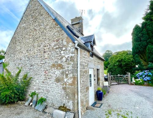 une ancienne maison en pierre avec un toit solaire dans l'établissement Le Petit Fleur - the little flower, cosy cottage, à Saint-Michel-de-Montjoie