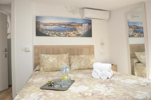 ein Schlafzimmer mit einem Bett und einem Tablett darauf in der Unterkunft Alojamiento del Sol in Málaga
