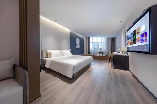 une chambre d'hôtel avec un lit et une télévision à écran plat dans l'établissement Atour Hotel Suqian West Lake Road Golden Eagle Plaza, à Suqian