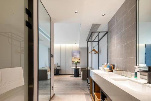 a bathroom with two sinks and a living room at Atour Hotel Luqiao Taizhou in Taizhou