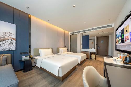 Cette chambre comprend 2 lits et une télévision à écran plat. dans l'établissement Atour Hotel Taizhou Linhai Toumen Port, à Linhai