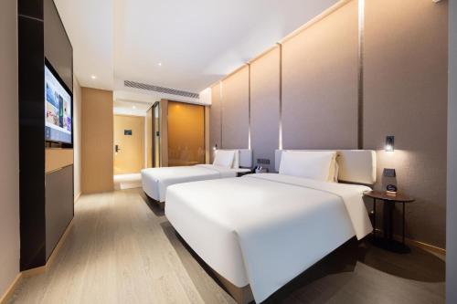Ένα ή περισσότερα κρεβάτια σε δωμάτιο στο Atour Hotel Nanjing Pukou Economic Development Zone Qiaolin