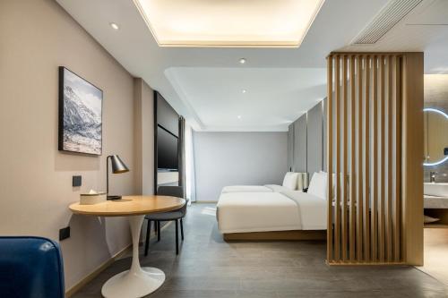 a hotel room with a bed and a table at Atour Hotel Xinghua Dainan in Xinghua