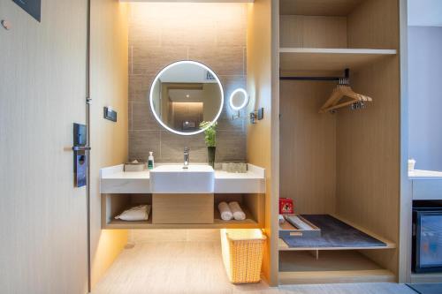 a bathroom with a sink and a mirror at Atour Hotel Wuhan University of Technology Jiedaokou in Wuhan