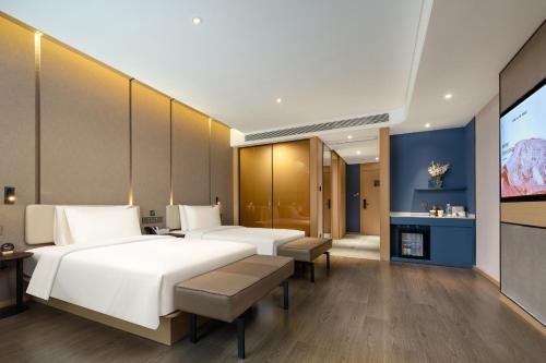 a hotel room with two beds and a television at Atour Hotel Kunshan Chengdong Development Zone in Kunshan