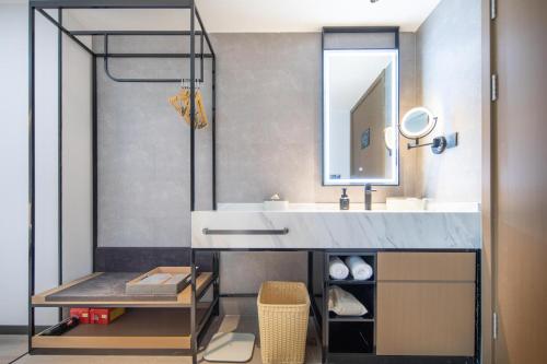 a bathroom with a sink and a mirror at Atour Hotel Suqian Industrial Park Wuyue Plaza in Suqian