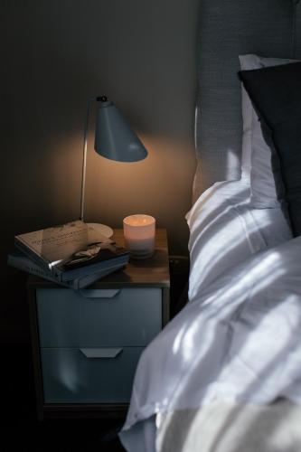 a lamp on a night stand next to a bed at Panorama Landscape Hotel in Nilsiä