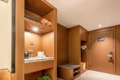 una pequeña cocina con armarios de madera y una puerta en Atour X Hotel Taizhou Jiangyan, en Taizhou