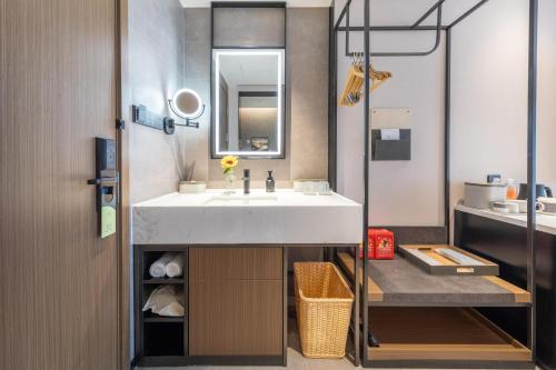 uma casa de banho com um lavatório e um espelho em Atour Hotel Guangzhou Panyu Jewelry City em Guangzhou