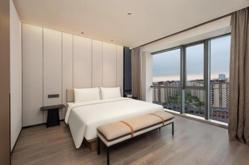 a bedroom with a bed and a large window at Atour Hotel Nantong Longxin Plaza in Nantong
