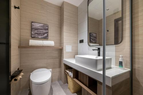 een badkamer met een wit toilet en een wastafel bij Atour Hotel Linqing City Center Liaocheng in Linqing