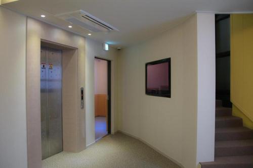 a hallway with stairs and a television on a wall at Uniqstay in Busan