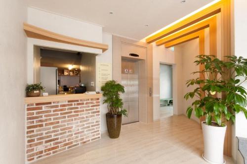 a hallway with two potted plants in a building at Uniqstay in Busan