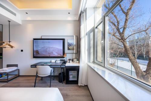 a room with a desk and a large window at Atour X Hotel Shenyang Beiling Park in Shenyang