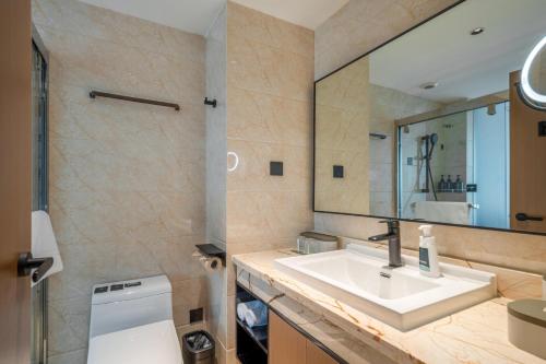 a bathroom with a sink and a mirror at Atour X Hotel Hangzhou Wenyi Road in Hangzhou