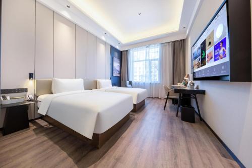 Atour X Hotel Shenyang Beiling Park في شنيانغ: غرفة فندقية بسرير كبير وتلفزيون بشاشة مسطحة