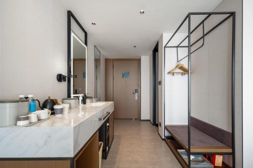 ein Badezimmer mit einer Theke mit 2 Waschbecken und einem Spiegel in der Unterkunft Atour Hotel Dali Erhai Park in Dali