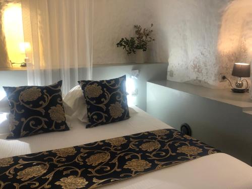 a bedroom with a bed and two pillows at Logis Hôtels Troglododo in Azay-le-Rideau