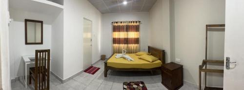 a bedroom with a yellow bed in a room at The Lake Round Guest House in Kandy