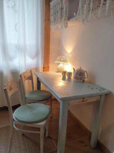 a table with two chairs and a tea kettle on it at Cichosza - The Sound Of Silence in Białowieża