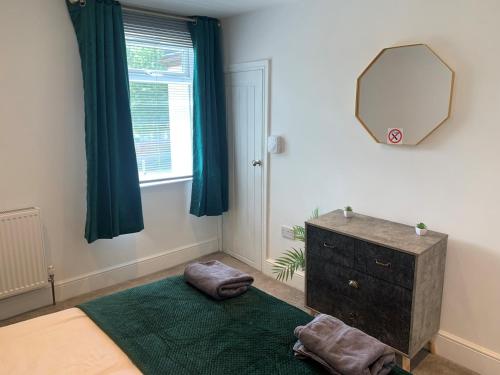 1 dormitorio con espejo, 1 cama y vestidor en Alsager Town Centre Apartment en Alsager