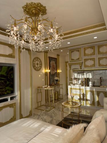 a living room with a bed and a chandelier at City View at The Gramercy Residences in Makati