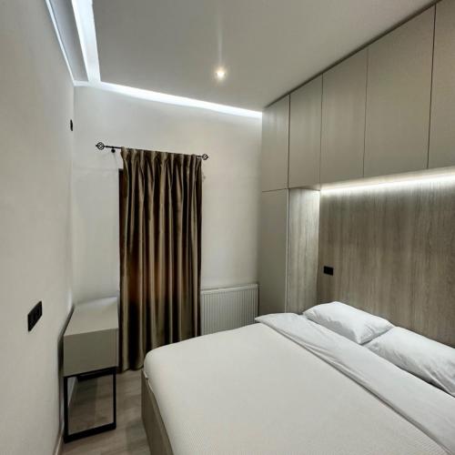 - une chambre avec un lit blanc et une fenêtre dans l'établissement Sara Apartment, à Strumica