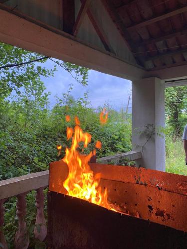 ein Feuer brennt in einem Außengrill mit in der Unterkunft Гостевой дом in Ekadiya
