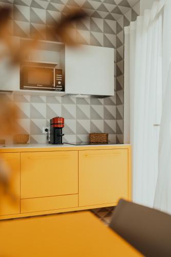 a kitchen with a yellow cabinet and a microwave at Methe in Lizzano