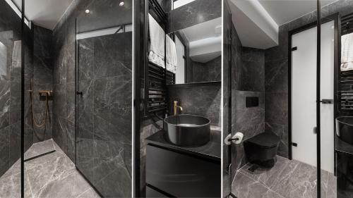 a black bathroom with a sink and a shower at #FLH -The Koi Apartment, Thessaloniki in Thessaloniki